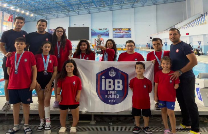 İBB Spor Kulübü Para Yüzme sporcuları ile antrenörler havuz başında poz veriyor.