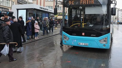 Fotoğrafta, yağışlı havada bir şehir içi otobüsü durakta yolcu almak üzere bekliyor. Durakta otobüsü bekleyen vatandaşlar görülürken, otobüsün ön ekranında "Fatih" hattı yazıyor. Yolda ıslak zemin ve çevredeki binalar dikkat çekiyor.