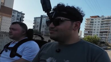 Kent ortamında yan yana iki akülü sandalyeyle Furkan Ulusoy ve Batuhan Fidan seyahat ediyor, Furkan Ulusoy ise başına taktığı aksiyon kamerasıyla görüntü kaydı alıyor.