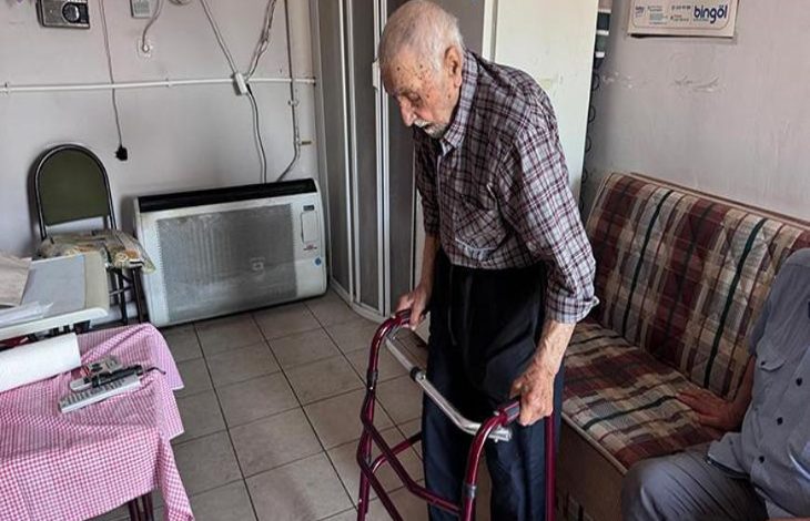 Niyazi Vural çay ocağında medikal yürüteç tutarak geziyor.