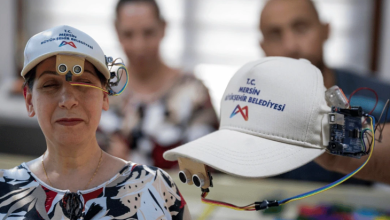 Bir kadının başında, üzerinde elektronik sensörler ve bağlantı kabloları bulunan MERSULA sistemi yer alıyor. Yan tarafta sistemin elektronik bileşenlerinin monte edildiği şapka görülüyor.