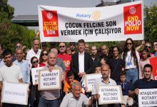 Görselde, Rotary Kulübü üyeleri ve gönüllüler, ”Çocuk Felcine Son Vermek İçin Çalışıyor” yazılı bir pankart ve farklı Rotary kulüplerinin isimlerinin yer aldığı dövizlerle bir araya gelerek çocuk felcine karşı farkındalık oluşturuyor.
