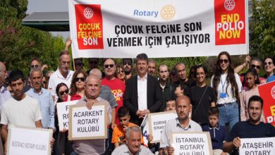 Görselde, Rotary Kulübü üyeleri ve gönüllüler, ”Çocuk Felcine Son Vermek İçin Çalışıyor” yazılı bir pankart ve farklı Rotary kulüplerinin isimlerinin yer aldığı dövizlerle bir araya gelerek çocuk felcine karşı farkındalık oluşturuyor.