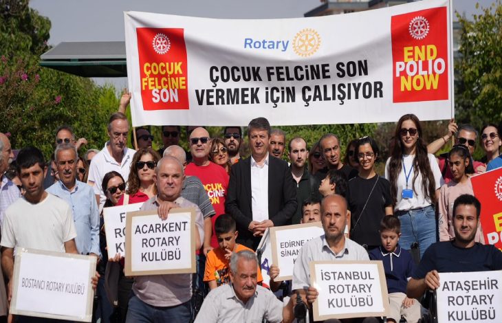 Görselde, Rotary Kulübü üyeleri ve gönüllüler, ”Çocuk Felcine Son Vermek İçin Çalışıyor” yazılı bir pankart ve farklı Rotary kulüplerinin isimlerinin yer aldığı dövizlerle bir araya gelerek çocuk felcine karşı farkındalık oluşturuyor.