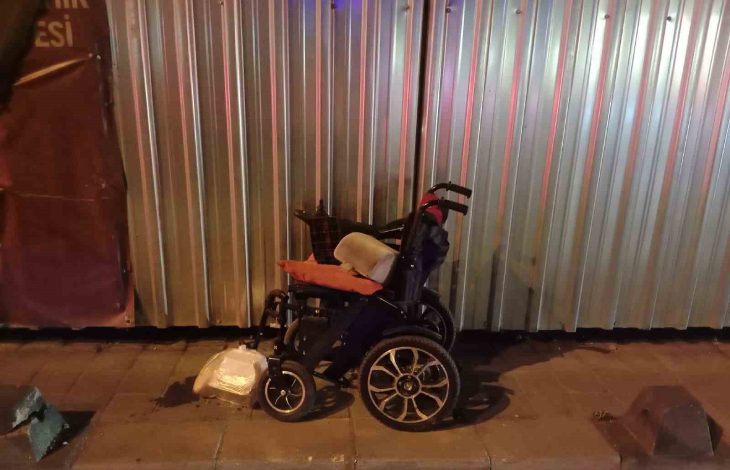 Çarpma sonucu zarar gören akülü tekerlekli sandalye kaldırımda duruyor.