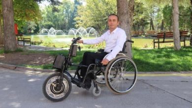 Anadolu Üniversitesi personeli Recep Çetin, motor aparatlı tekerlekli sandalyede oturuyor.