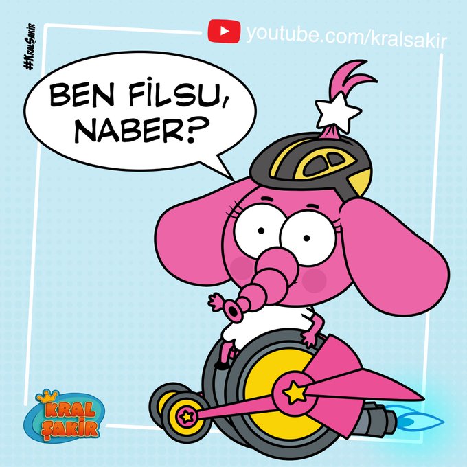 Pembe bir fil karakteri, sarı-siyah bir kask ve beyaz bir kıyafetle, roketli tekerlekli bir araç üzerinde oturuyor. Konuşma balonunda “Ben Filsu, naber?” yazıyor. Arka planda açık mavi tonlar ve “Kral Şakir” ile YouTube logosu bulunuyor.