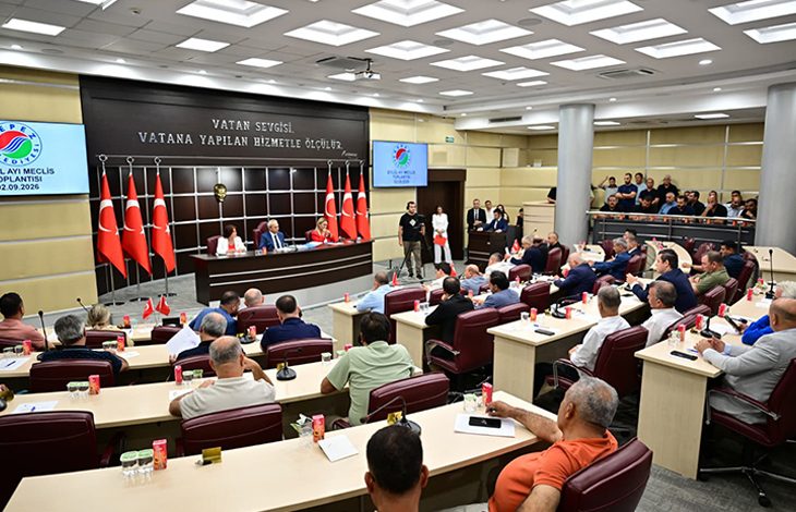 Geniş ve resmi bir meclis salonunda, sıralı masalara oturmuş çok sayıda katılımcı toplantıyı takip ediyor. Ön tarafta konuşmacıların bulunduğu kürsü yer alıyor; arkada Türk bayrakları ve duvarda “Vatan sevgisi, vatana yapılan hizmetle ölçülür” yazısı dikkat çekiyor. Büyük ekranlarda “Kepez Belediyesi – Eylül Ayı Meclis Toplantısı 02.09.2026” ifadesi yer alıyor. Salon düzenli, kalabalık ve resmi bir toplantı atmosferi taşıyor.