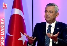 Stüdyoda takım elbise ve kravatıyla oturan Yeni Parti Genel Başkanı, canlı yayında konuşurken iki elini hafifçe yukarı doğru açmış şekilde jest yapıyor. Arka planda mor ve pembe tonlarda aydınlatılmış bir stüdyo atmosferi bulunuyor. Sağ tarafta büyük bir Türk bayrağı yer alıyor. Sol tarafta kırmızı zemin üzerinde beyaz harflerle “SON DAKİKA” yazısı ve onun üstünde kanalın logosu görünüyor. Genel başkan, ciddi ve odaklanmış bir ifadeyle gündeme dair açıklama yapıyor gibi görünüyor.