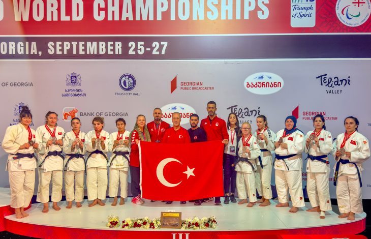 Para Judo Millî Takımımız ve teknik kadro Türk bayrağı açarak törende poz veriyor.