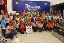 İşitme engelliler ve aileleri, bowling turnuvasında anı fotoğrafı çektiriyor.
