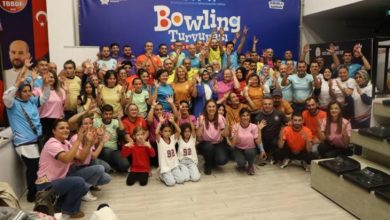 İşitme engelliler ve aileleri, bowling turnuvasında anı fotoğrafı çektiriyor.