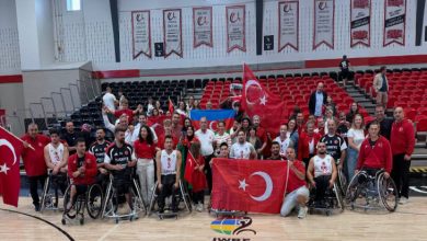 Kadrajın merkezinde, tekerlekli sandalyedeki Türkiye milli takım oyuncuları ve teknik ekip yer alıyor.