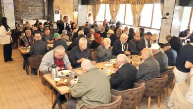 Yemek masasında karşılıklı oturan yaşlılar kahvaltı yapıyor.