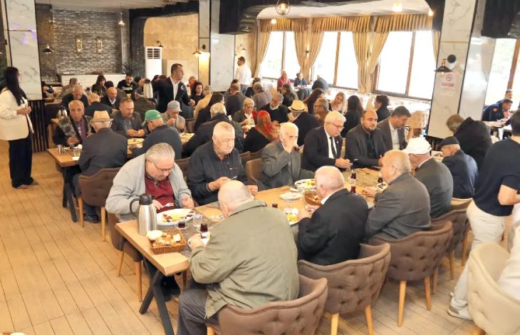 Yemek masasında karşılıklı oturan yaşlılar kahvaltı yapıyor.