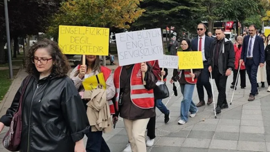 Görselin üst bölümünde, bir cadde üzerinde yürüyüş düzenleyen kalabalık bir grup yer almaktadır. Gruptakiler ellerinde "Engel Fizikte Değil Yürektedir" ve "En Büyük Engel Sevgisizliktir" yazılı pankartlar taşırken, bazı görme engelli katılımcılar beyaz bastonlarıyla yürüyüşe eşlik etmektedir.