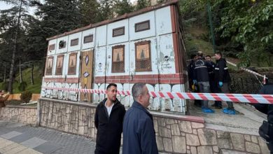 Elektrik trafosunun etrafı kırmızı beyaz şeritle çekilmiş ve yanında polis personelleri bulunuyor.