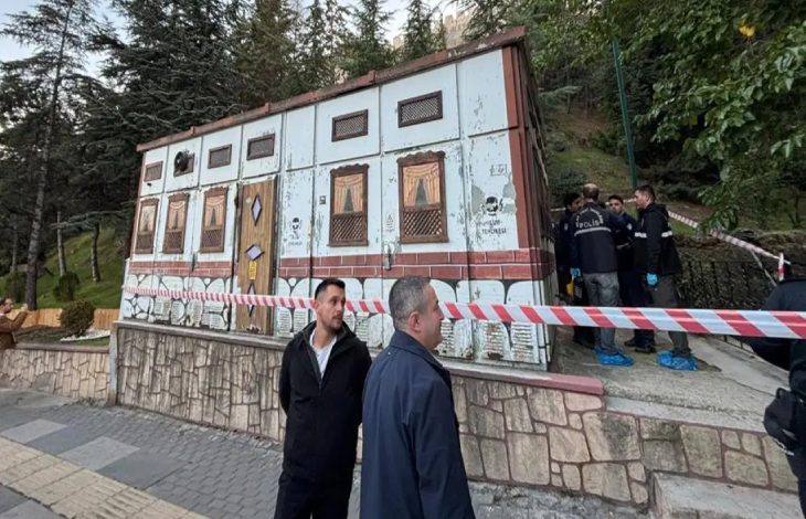 Elektrik trafosunun etrafı kırmızı beyaz şeritle çekilmiş ve yanında polis personelleri bulunuyor.