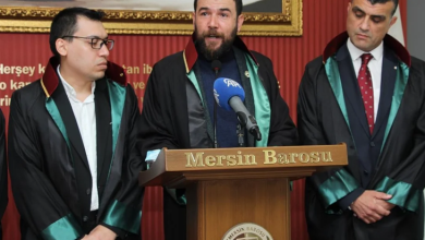 Görselin üst bölümünde, "Mersin Barosu" yazılı kürsüde avukatlık cübbesi giymiş bir avukat basın açıklaması yaparken, yanında destek amacıyla bulunan diğer iki avukatla birlikte yer almaktadır. Ortada sakallı ve cübbeli olarak konuşmayı yapan avukatın sağında gözlüklü, solunda ise koyu takım elbiseli ve kırmızı kravatlı meslektaşları ciddiyetle dinlemektedir. Arka planda kırmızı tonlarda pano ve üzerinde adalet temalı görseller ile yazılar bulunmaktadır.