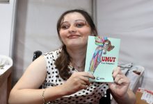 Esra Doğramacı, Umut isimli kitabını elinde tutuyor.