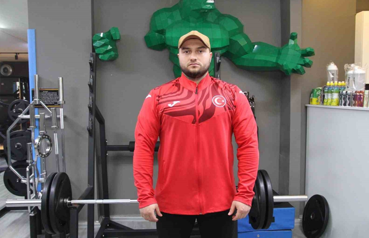 Görselin üst bölümünde, spor salonunda ağırlık çalışma istasyonunun önünde dimdik durarak kararlı bir bakışla doğrudan kameraya odaklanan görme engelli milli sporcu Şimşek yer alıyor. Başında bej renkli bir beyzbol şapkası, üzerinde göğsünde Türk bayrağı amblemi bulunan kırmızı milli takım fermuarlı üstü ve altında siyah spor pantolonu bulunuyor. Sporcunun önünde halter barı ve ağırlık plakaları, hemen arkasındaki duvarda ise geometrik formda tasarlanmış yeşil dev bir çizgi roman karakteri figürü (Hulk) ile spor salonu ekipmanları görülüyor.