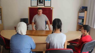 Görselde, rehber öğretmen Hasan Akyürek sınıfta öğrencilerin karşısında masa başında durarak ders anlatırken, öğrenciler dikkatle onu dinlemektedir.