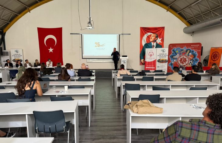 Görselde, Türk bayrakları ve Atatürk posteriyle süslenmiş bir salonda, katılımcıların masa başında oturarak bir konuşmacının sunumunu dinlediği spor ve yaşlılık temalı bir kongre veya eğitim etkinliği görülmektedir.
