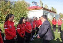 İşitme Engelliler Kadın Güreş Milli Takımı sporcuları, İşitme Engelliler Spor Federasyonu Başkanı Dursun Gözel ile iletişim kurarken samimi ve gülümseyen anlar görsele yansıyor.