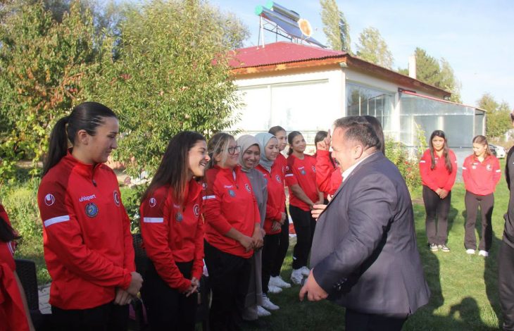 İşitme Engelliler Kadın Güreş Milli Takımı sporcuları, İşitme Engelliler Spor Federasyonu Başkanı Dursun Gözel ile iletişim kurarken samimi ve gülümseyen anlar görsele yansıyor.