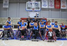 İzmir BBSK Tekerlekli Sandalye Basketbol Takımı oyuncuları basketbol sahasında poz veriyor.