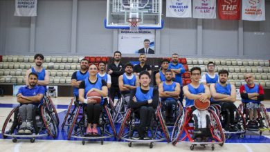 İzmir BBSK Tekerlekli Sandalye Basketbol Takımı oyuncuları basketbol sahasında poz veriyor.