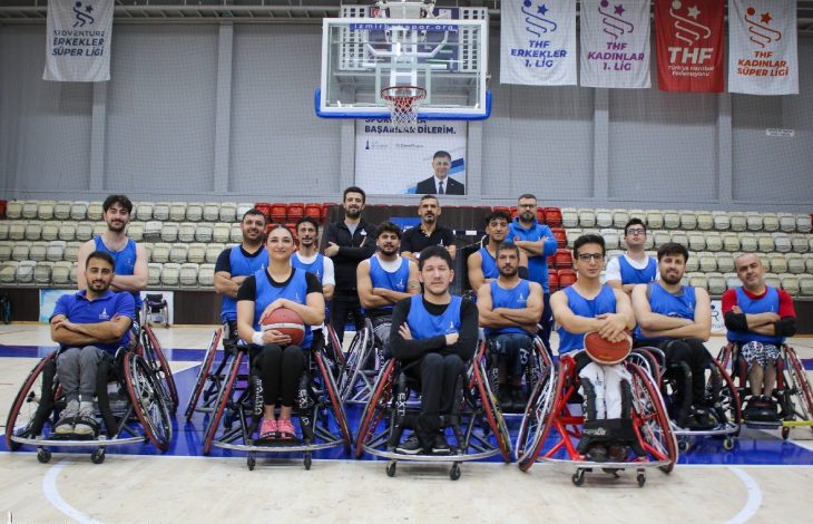 İzmir BBSK Tekerlekli Sandalye Basketbol Takımı oyuncuları basketbol sahasında poz veriyor.
