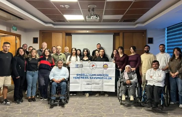 Eğitim programına katılanlar, “Engelli Hakları İçin Yeni Nesil Savunuculuk” yazılı pankartın önünde toplu fotoğraf çektiriyor.