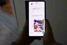 Görselde, bir kişinin elleri arasında tuttuğu akıllı telefon ekranında mesajlaşma uygulamasına ait bir sohbet ekranı görünmektedir. Ekran üzerinde yazışmalar ve pembe tonlarında bir fincan takımı görseli yer almaktadır.