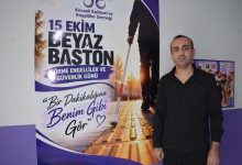 Görselde, üzerinde "15 EKİM BEYAZ BASTON GÖRME ENGELLİLER VE GÜVENLİK GÜNÜ" ve "Bir Dakikalığına Benim Gibi Gör" yazılarının bulunduğu afişin önünde duran siyah gömlekli bir erkek yer almaktadır. Görselin alt kısmındaki mor şerit üzerinde beyaz, kalın harflerle Türkçe olarak: "Kocaeli Darıca'da Katılımcılar Görme Engelliler İçin 1 Dakika Bastonla Yürüdü" başlığı; hemen altında ise yasadikca.com internet sitesi adresi ile platformun beyaz renkli kanat logolu amblemi yer almaktadır.