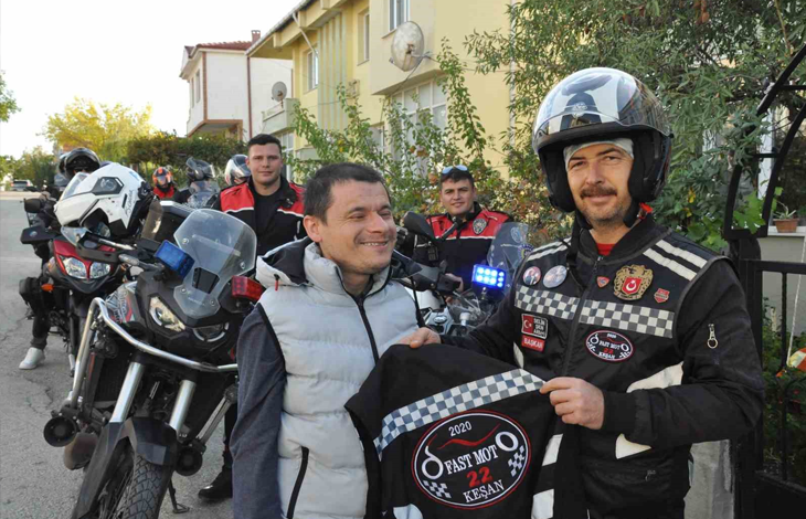Görselde, bir sokakta bir araya gelmiş motosikletli grup ile görme engelli Sezgin Çalışkan yer almaktadır. Sağ tarafta kask takmış ve üzerinde "FAST MOTO 22 KEŞAN" yazılı kulüp yeleği bulunan bir motosikletçi, Sezgin Çalışkan'a yeleği gösterirken; sol tarafta açık renk yelek giyen Sezgin Çalışkan gülümsemektedir. Arka planda ise park edilmiş motosikletler ve diğer grup üyeleri görülmektedir.