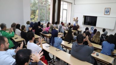 Sınıfta öğretmenin yönlendirmesiyle sıralarında oturan öğrenciler, elleriyle işaret dili terimi yapmakta ve etkileşimli bir öğrenme ortamı oluşturmaktadır.