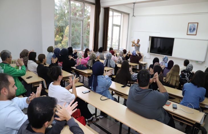 Sınıfta öğretmenin yönlendirmesiyle sıralarında oturan öğrenciler, elleriyle işaret dili terimi yapmakta ve etkileşimli bir öğrenme ortamı oluşturmaktadır.