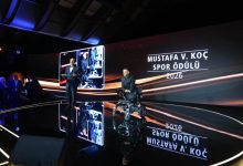 2026 Mustafa V. Koç Spor Ödülü’nün sahibi olan Para Milli yüzücü Umut Ünlü, tören sahnesinde tekerlekli sandalyesiyle yer alırken, ödül anına eşlik eden sunucu ve arka plandaki görsel ekranda ödülün adı ile yılı dikkat çekiyor.