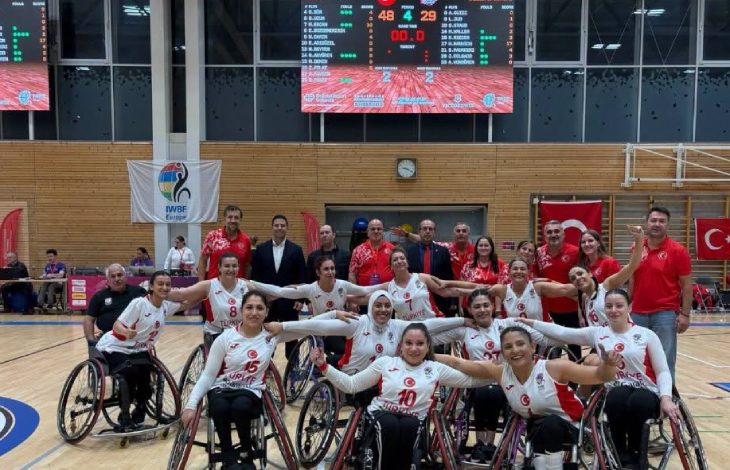 Tekerlekli Sandalye Basketbol Kadın Millî Takımı oyuncuları birbirlerinin omuzlarını tutarak poz veriyor.